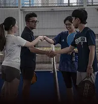 Empat pemain padel bersalaman bersama di lapangan indoor